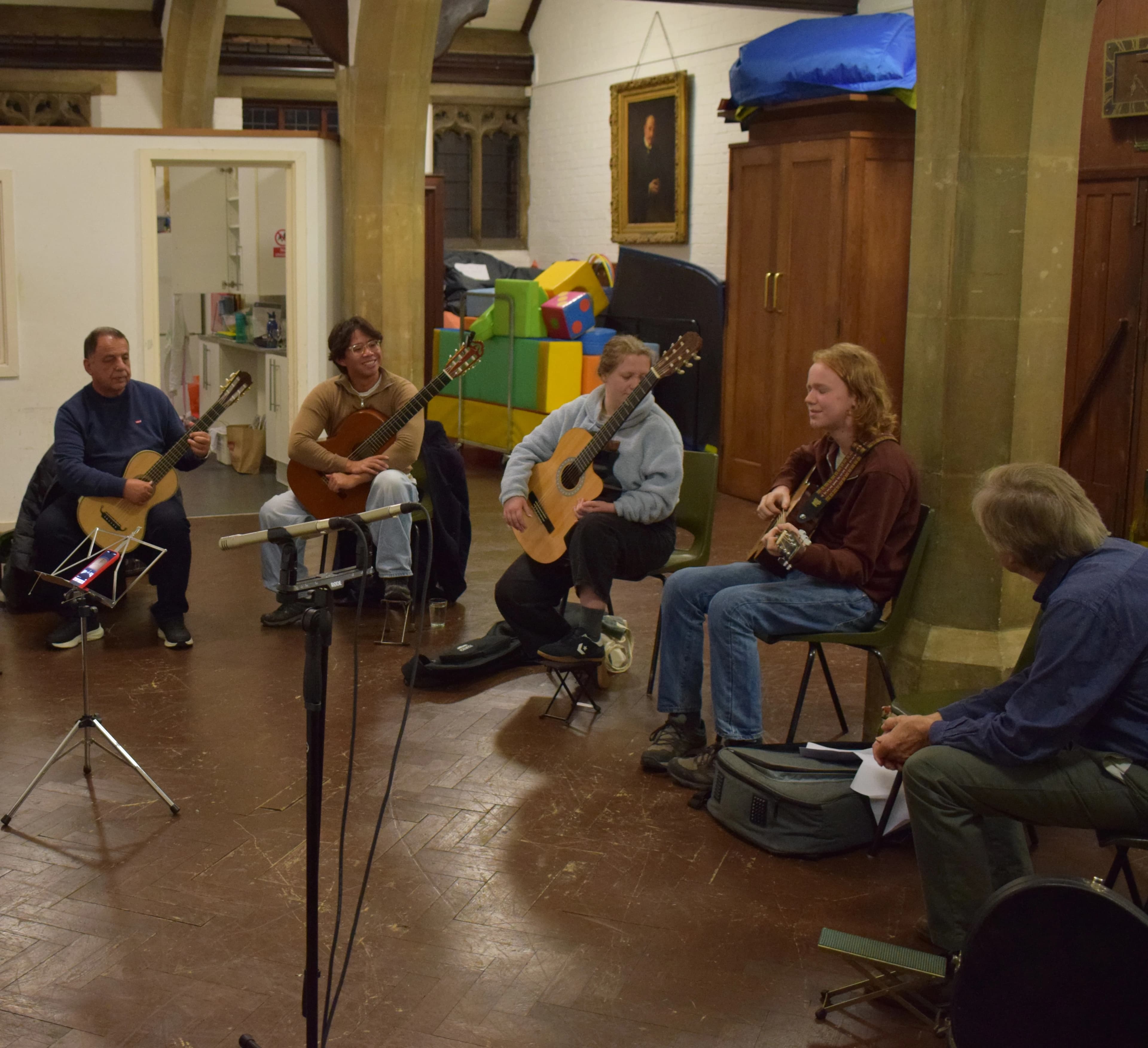 Classical guitarists playing together in a circle in a church hall